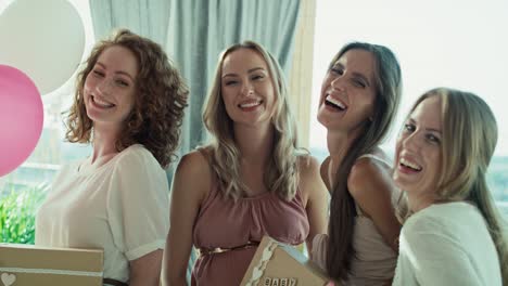 Group-of-caucasian-women-with-presents-at-baby-shower-looking-at-camera-side.