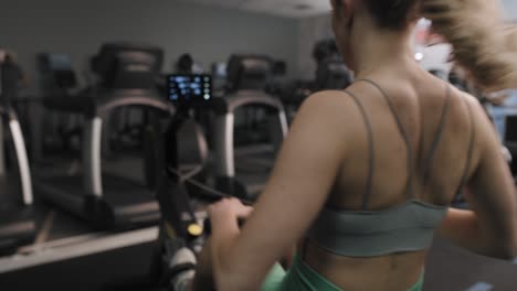 Back-view-of-woman-exercising-on-rowing-machine.