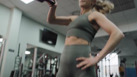 Young-caucasian-woman--exercising-with-kettlebells-at-a-gym.