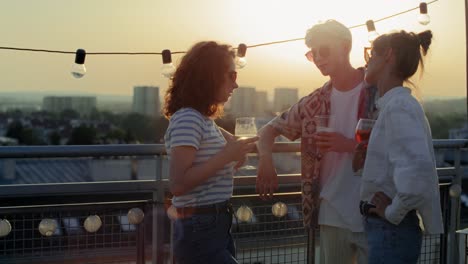 Young-adult-friends-talking-together-at-the-party-during-the-sunset.