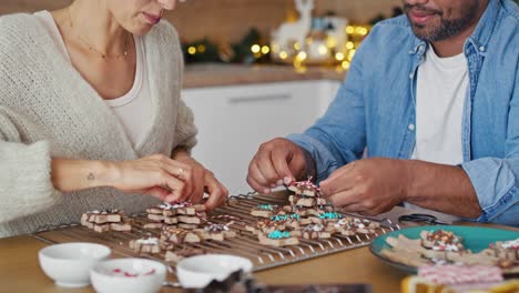 Multi-ethnicity-couple-packing-gingerbread-cookies-as-small-Christmas-gifts.