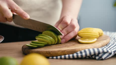 Close-up-of-woman-cutting-lime-in-the-kitchen.