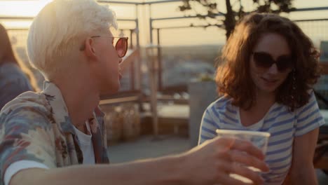 Caucasian-couple-talking-together-at-the-roof-top-party-during-the-sunset.