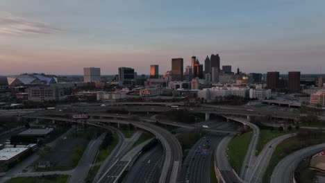 Eine-Filmische-Luftaufnahme-Der-Innenstadt-Von-Atlanta-Während-Der-Hauptverkehrszeit-Mit-Blick-Auf-Berühmte-Skyline-Gebäude-Im-Hintergrund,-Verkehr-Auf-Der-Autobahn-In-Einer-Modernen-Stadt