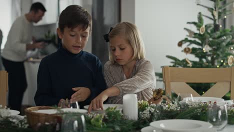 Dos-Niños-Caucásicos-Preparando-La-Mesa-Para-La-Víspera-De-Navidad.