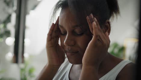 Nahaufnahme-Einer-Afroamerikanischen-Frau-Mit-Großen-Kopfschmerzen,-Die-Im-Badezimmer-Steht.