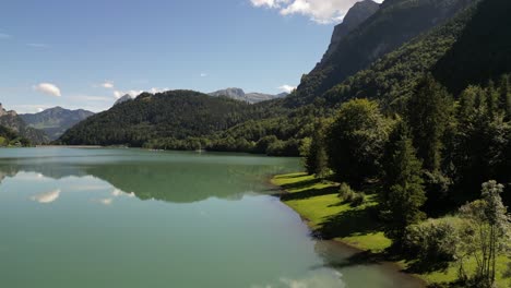 Majestic-Peaks,-Crystal-Waters:-Aerial-view-of-green-forest-and-Lakeside-Mountains
