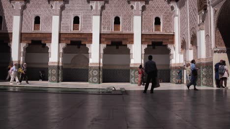 Erkunden-Sie-Das-Sonnige-Innere-Des-Ben-Youssef-Islamic-College,-Ein-Meisterwerk-Des-Handwerks-Und-Der-Architektur,-Im-Pulsierenden-Marrakesch,-Während-Touristen-Herumschlendern