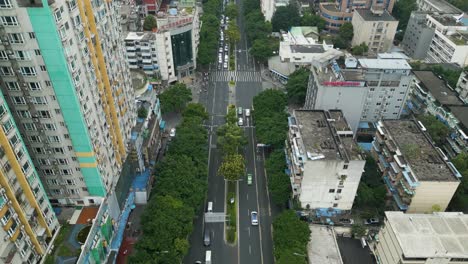 Aerial-tracking-shot-by-drone-of-traffic-on-busy-road-sournedned-by-high-raise-building-in-china-chengdhu