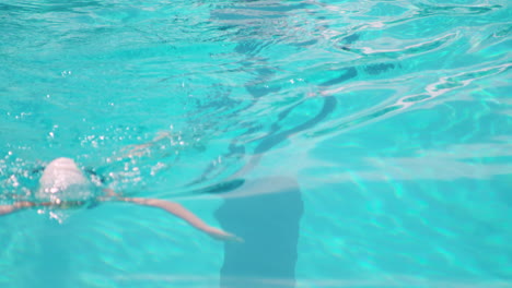 High-angle-close-up-of-female-athlete-with-cap-and-glasses-swimming-in-pool