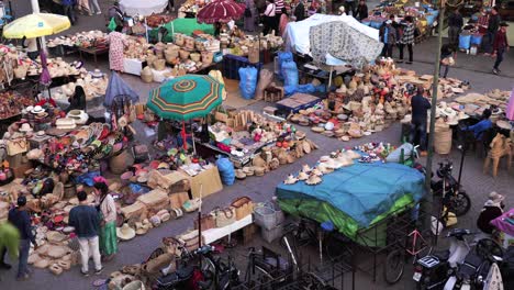 Exploring-the-colourful-and-bustling-outdoor-flea-market-in-Marrakesh,-a-vibrant-scene-of-tourism-and-Moroccan-bazaar-culture,-full-of-oriental-and-traditional-crafts