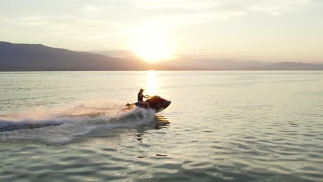 Woman-Riding-Jet-Ski-Sea-Doo-at-Sunset-on-Utah-Lake---Aerial-in-Slow-Motion
