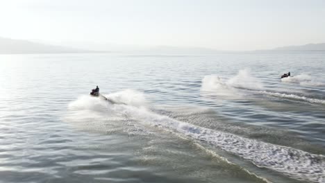 Three-Riders-Racing-Jet-Ski-Waverunners-on-Utah-lake,-Aerial-with-Copy-Space