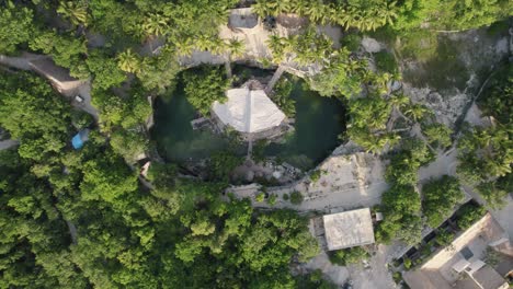 Descending-aerial-over-Buuts'-Ha'-Cenote-Club,-Mexico