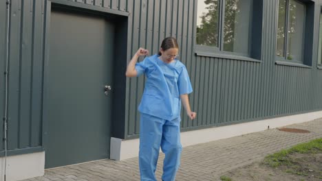 Female-nurse-steps-out-of-work-and-starts-to-dance