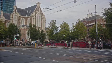 Tilt-down-from-Westerkerk-to-busy-road-in-Amsterdam,-the-Netherlands