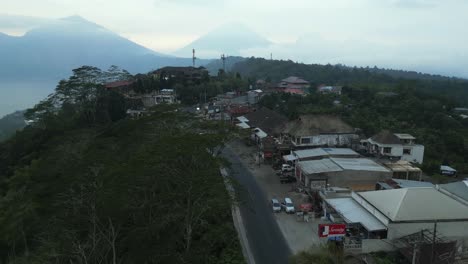Mountain-aerial-follows-cars-on-cliff-top-road-at-Mount-Batur-on-Bali