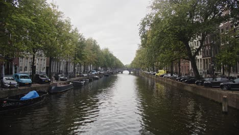 Wide-view-of-beautiful-and-peaceful-Amsterdam-canal-on-a-cloudy-day