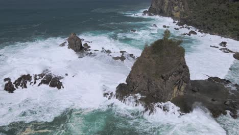 Power-of-ocean-hitting-rocky-shore,-aerial-view