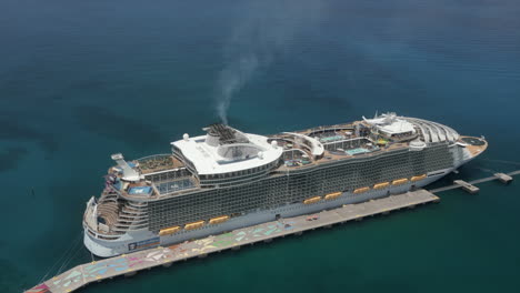 Royal-Caribbean-cruiseship-moored-at-Bahamas-cay-pier,-aerial-view