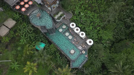 Flyover-multi-level-swimming-pool-with-waterfall-on-tropical-hillside