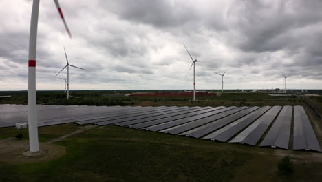 Campo-De-Energía-Verde-Con-Plantas-Eólicas-Y-Solares,-Vista-Aérea
