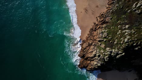 Aerial-Top-Down-Over-Coastal-Beach-and-Rocky-Cliffs-in-Cornwall,-UK