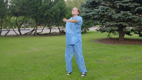 Happy-nurse-dancing-on-green-grass-after-work,-front-view