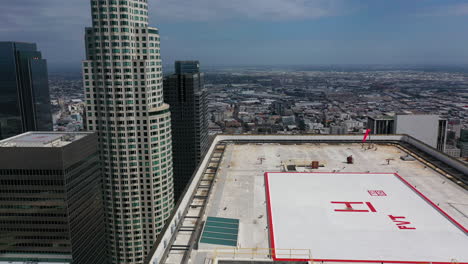 Aerial-view-over-a-helipad-on-top-of-a-skyscraper-in-downtown-Los-Angeles,-USA