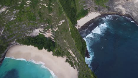 Kelingking-Beach-Viewpoint-on-Nusa-Penida-island-and-hiking-trail-on-ridge-of-a-steep-rock-face-cliff-down-to-white-sand-cove