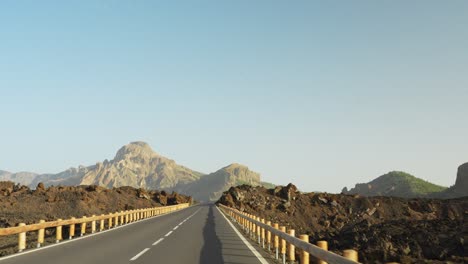 Highway-road-leading-toward-mountain-of-Teide-national-park,-POV-driving