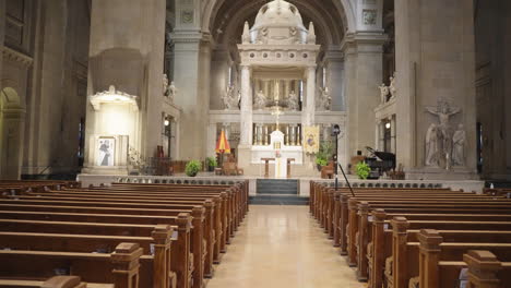 Walking-Down-Central-Aisle-of-Ornate-Basilica,-Featuring-Pews,-Altar,-Statues,-and-Climaxing-with-a-Detailed-Ceiling-Dome-View