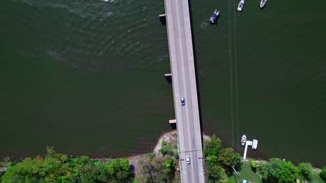 top-down-aerial-tracking-cars-above-bridge-Fox-River-in-Crystal-Lake,-Illinois,-USA