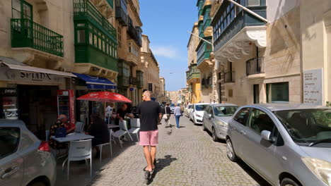Electric-Scooter-Ridden-by-Tourist-Through-Maltese-Narrow-Streets-of-Valletta,-Malta