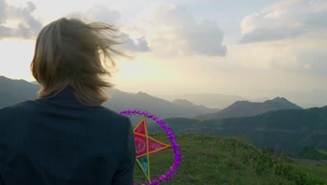 Slow-motion-shot-of-a-model-holding-a-star-lantern-at-a-mountain-top-at-sunset