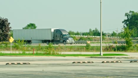 Slow-motion-of-a-grey-semi-truck-trailer-driving-on-interstate