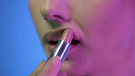 Extreme-close-up-shot-of-a-beautiful-young-womans-lip-as-she-presses-her-lips-together-to-spread-her-newly-applied-lipstick-after-getting-ready-for-club-night-evenly-in-slow-motion