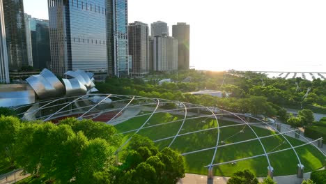 Jay-Pritzker-Pavilion-amphitheater-in-Millenium-Park-in-downtown-Chicago,-Illinois-during-beautiful-golden-hour-summer-sunrise-over-Lake-Michigan