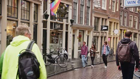 People-walking-past-of-one-of-the-oldest-gay-bars-in-Amsterdam,-the-Netherlands
