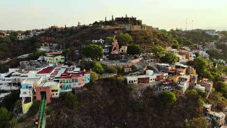 Drone-shot-in-front-of-the-El-Pipila-Monument,-sunset-in-Guanajuato-city,-Mexico