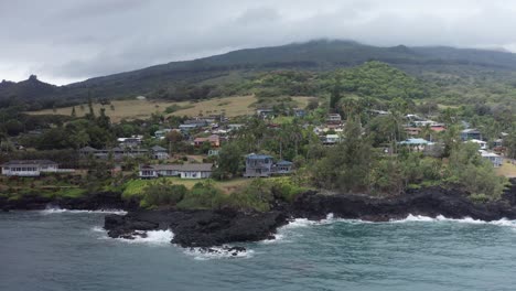 Low-aerial-dolly-shot-along-the-small-Hawaiian-village-of-Hana-on-the-windward-coast-of-Maui-in-Hawai'i