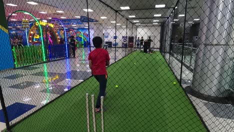 Kleine-Kinder-Spielen-Sehr-Gut-Cricket-Mit-Dem-Ball,-Der-Aus-Der-Automatischen-Wurfmaschine-In-Der-Spielzone-Kommt