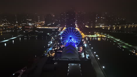 Drone-shot-tilting-toward-the-Centennial-Wheel,-at-the-hazy-Navy-pier-in-Chicago