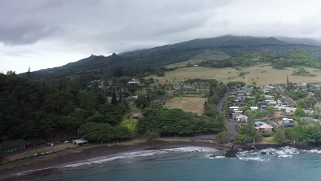 Aerial-wide-reverse-pullback-shot-of-the-small-Hawaiian-village-of-Hana-Town-on-the-windward-side-of-Maui-in-Hawai'i