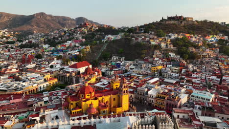 Flying-around-the-colorful-skyline-of-Guanajuato,-sunset-in-Mexico---Aerial-view
