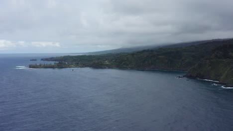Aerial-wide-panning-shot-of-the-rugged-coastline-along-the-Road-to-Hana-in-Maui,-Hawai'i