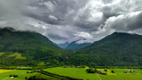 Lush-countryside-with-dramatic-cloud-formations-over-mountain