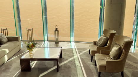 Luxuriöse-Inneneinrichtung-Mit-Eleganten-Möbeln,-Poolreflexionen-An-Den-Fenstern-Und-Durchströmendem-Sonnenlicht