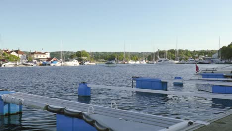 Blick-Vom-Hafen-Auf-Ein-Boot,-Das-über-Den-Fjord-In-Kragerø,-Norwegen,-Segelt
