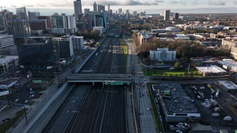 A-cinematic-drone-shot-reveals-moving-traffic-on-Downtown-Atlanta-Interstate-Highway-with-the-view-of-famous-skyscrapers-in-the-background-at-sunset